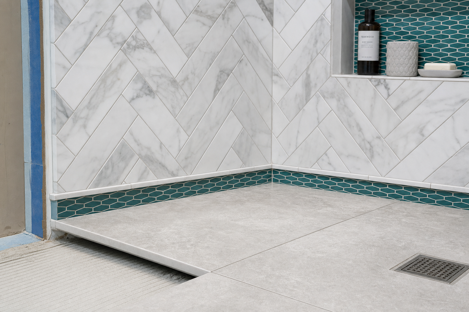 Bathroom tile installation with large-format porcelain floor and marble-look herringbone shower wall